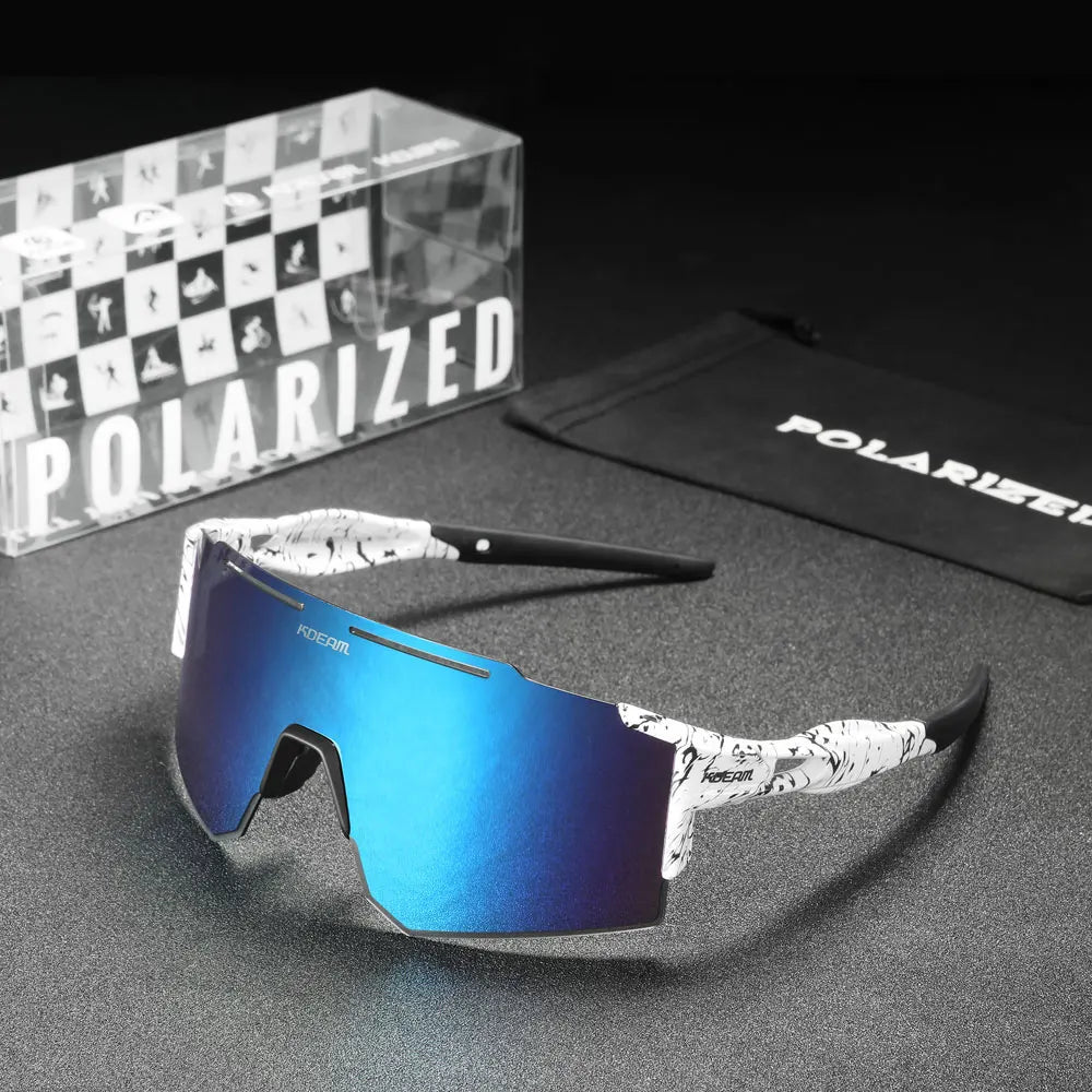 Blue reflective sunglasses with a black and white patterned arm on a gray surface, with 'Polarized' branding visible.