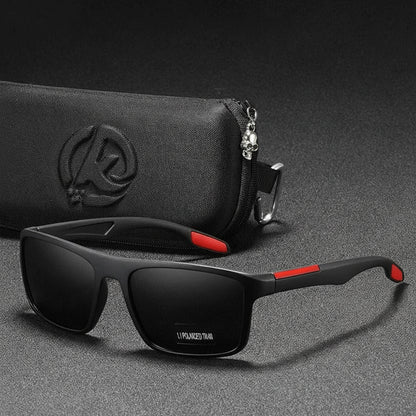 Black sunglasses with red accents on a gray surface with a black pouch in the background.