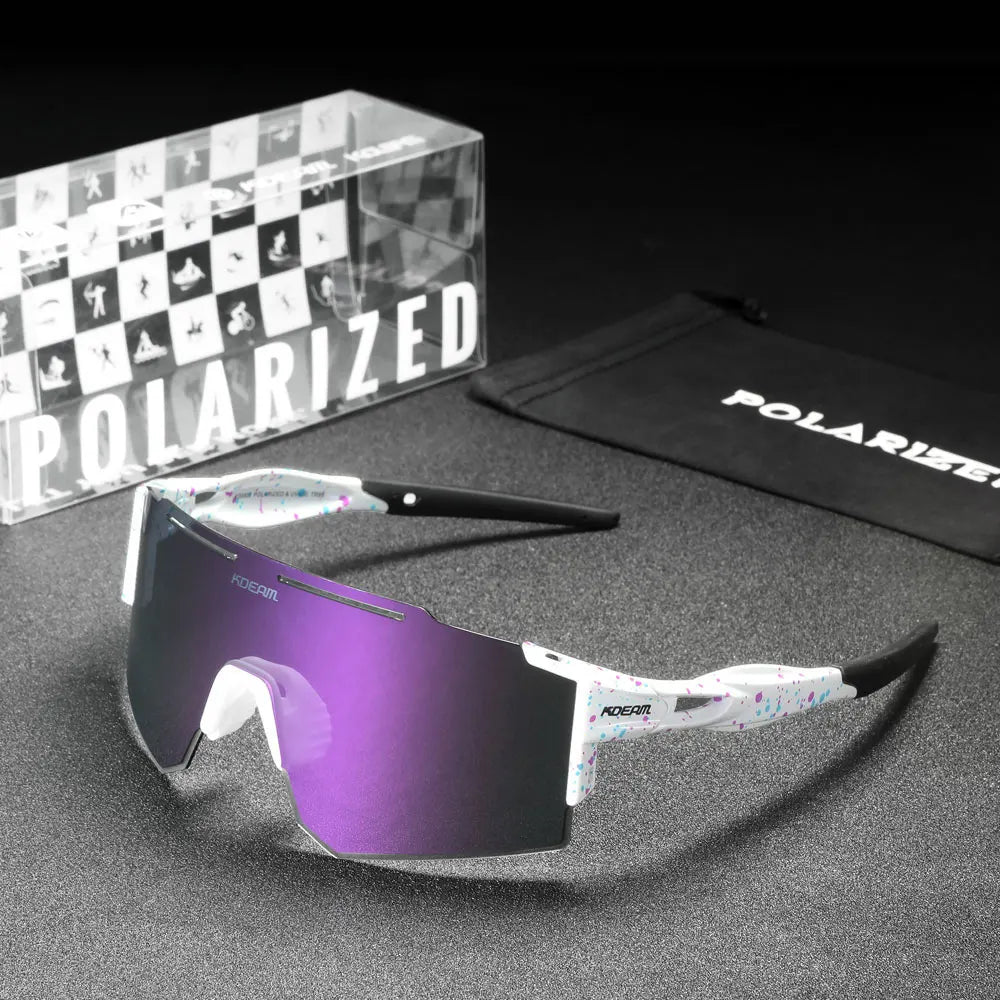 Polarized sunglasses with purple lenses, packaging, and case on a gray surface.